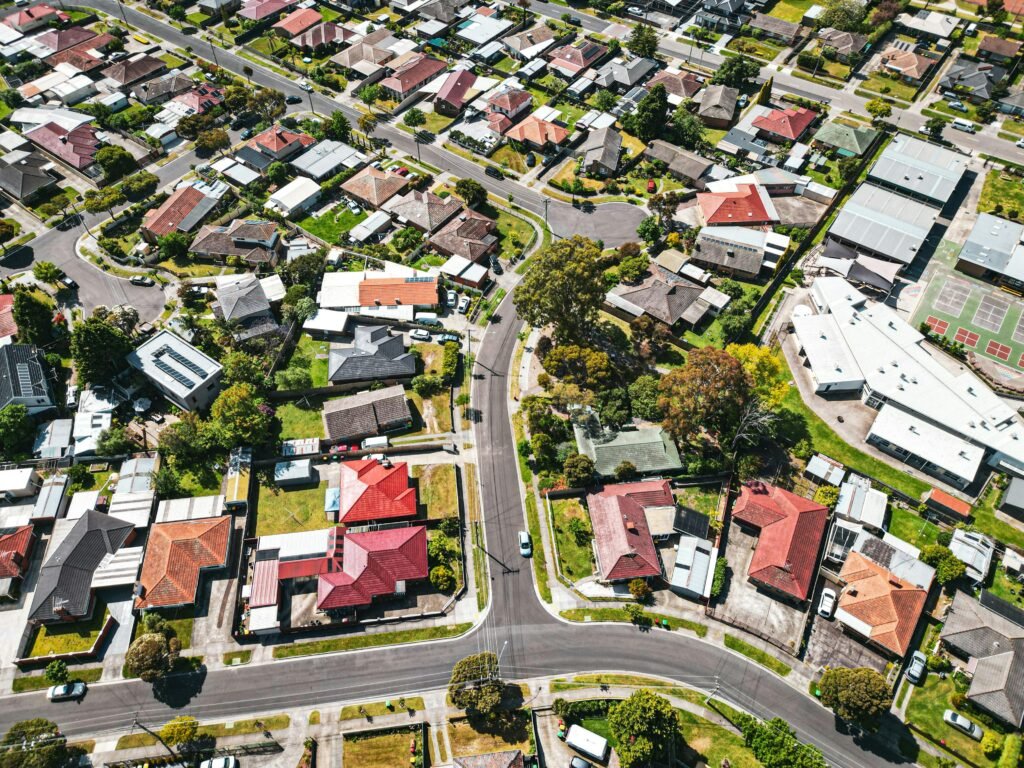 Drone shot capturing vibrant suburban area in Melbourne, Australia, showcasing varied architecture and greenery.